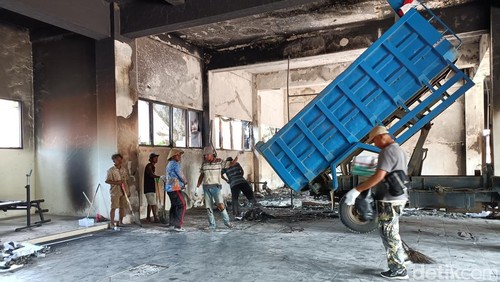 Sejumlah orang sedang membersihkan sisa puing gedung DPRD NTB yang terbakar pada saat aksi demonstrasi, Senin (1/9/2025). (Abdurrasyid Efendi/detikBali).
