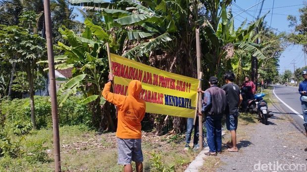 Spanduk protes terpasang di JJLS wilayah Karangwuni, Wates, Kulon Progo, Senin (1/9/2025).