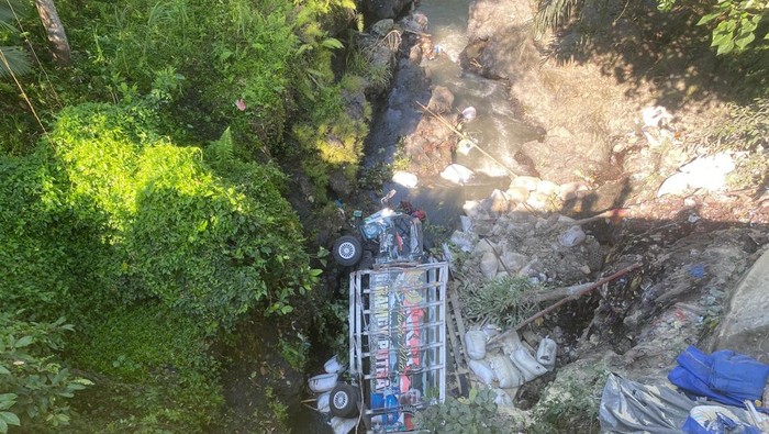 Tampak mobil truk bermuatan sekam padi terguling ke jurang puluhan meter di Desa Pemepek, Lombok Tengah.
