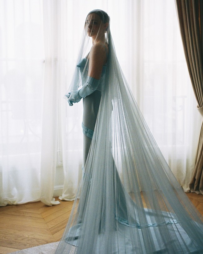 Berbeda dari kebanyakan mempelai wanita, Chloe memilih gaun berwarna biru dari rumah busana Louis Vuitton. Dalam foto, Chloe terlihat mengenakan strappy gown dengan detail ruffle dilengkapi sarung tangan dan veil transparan serba biru muda. Foto: Instagram Chloë Grace Moretz