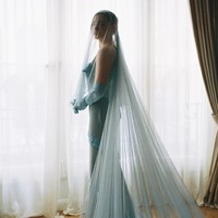 Berbeda dari kebanyakan mempelai wanita, Chloe memilih gaun berwarna biru dari rumah busana Louis Vuitton. Dalam foto, Chloe terlihat mengenakan strappy gown dengan detail ruffle dilengkapi sarung tangan dan veil transparan serba biru muda. Foto: Instagram Chloë Grace Moretz