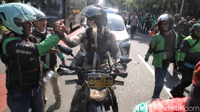 Driver Ojol Bagikan Bunga Saat Demo Damai di Monas Ratusan driver ojol membagikan bunga kepada warga dan aparat TNI-Polri saat aksi damai di kawasan Monas, Jakarta, Selasa (2/9/2025). Aksi ini berlangsung tertib dan penuh kehangatan.
