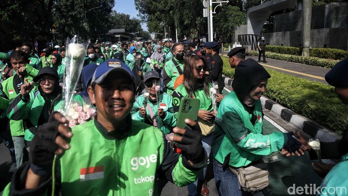 Ratusan driver ojol membagikan bunga kepada warga dan aparat TNI-Polri saat aksi damai di kawasan Monas, Jakarta, Selasa (2/9/2025). Aksi ini berlangsung tertib dan penuh kehangatan.