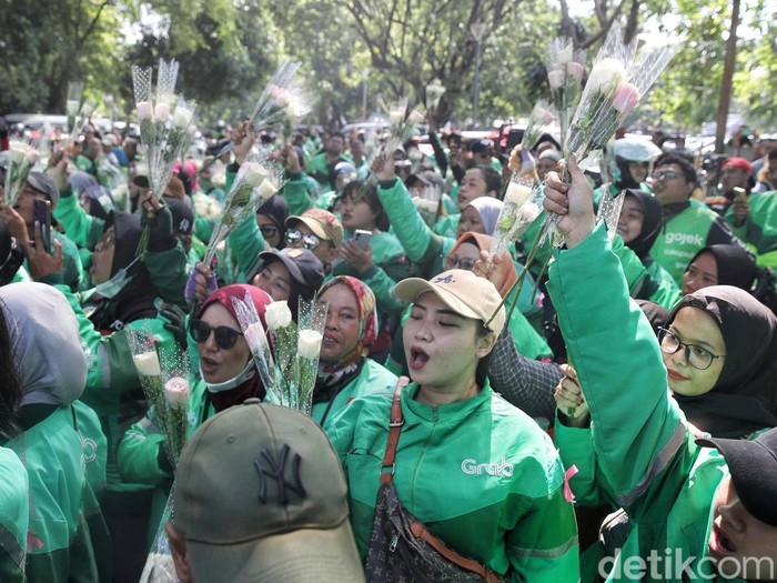 Ratusan driver ojol membagikan bunga kepada warga dan aparat TNI-Polri saat aksi damai di kawasan Monas, Jakarta, Selasa (2/9/2025). Aksi ini berlangsung tertib dan penuh kehangatan.