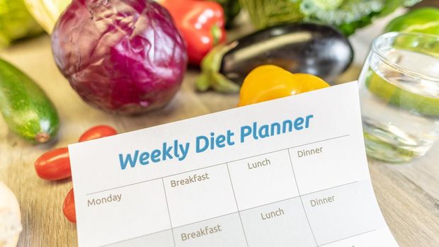 Weekly Diet Planner with healthy vegetables and a glass of water