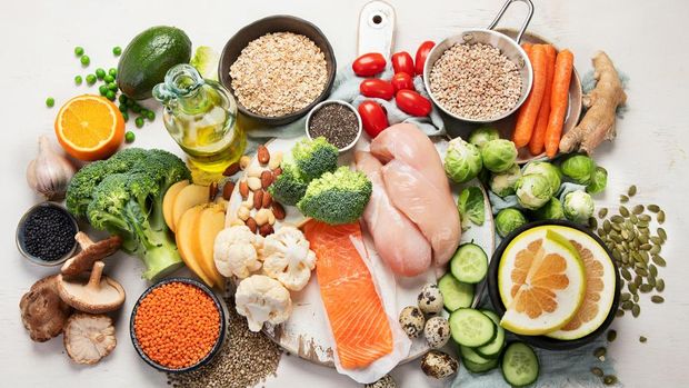 Healthy food selection on white background. Detox and clean diet concept. Foods high in vitamins, minerals and antioxidants. Anti age foods. Top view.