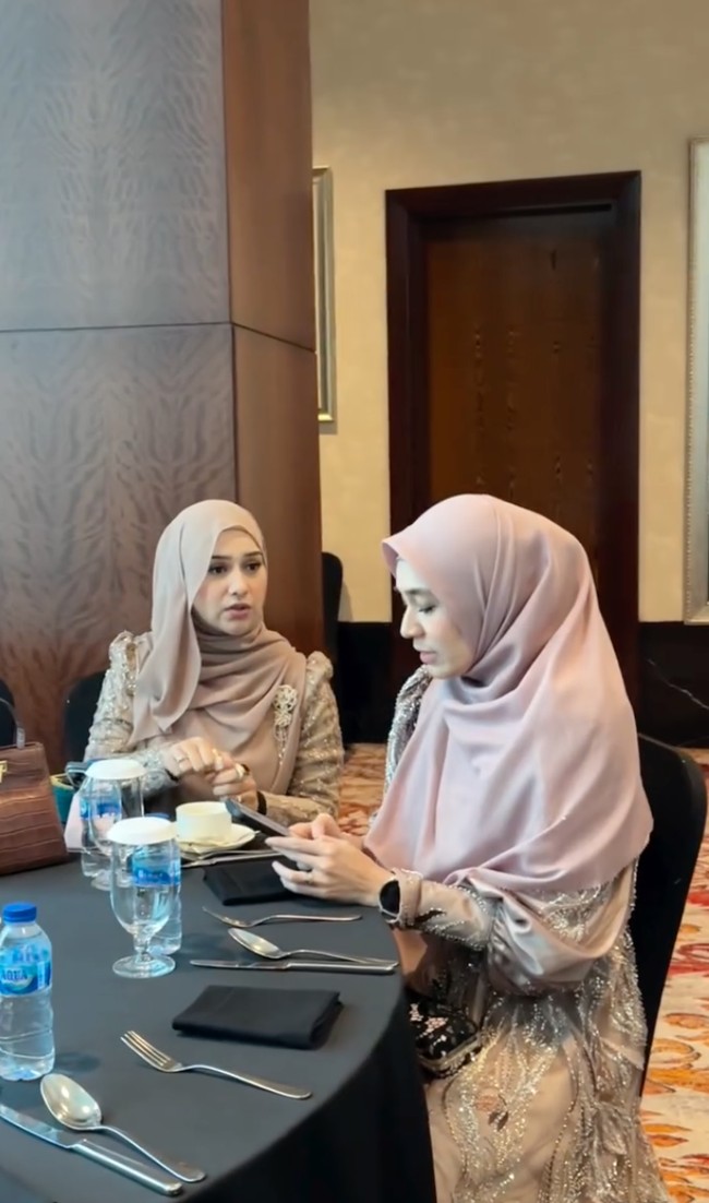 Irish dan Dhini sama-sama kenakan gaun panjang berwarna khaki. Penampilan keduanya tampak rapi dan santun dengan hijab yang menutup rambut dan kepalanya. Foto: Instagram/@dhiniaminarti