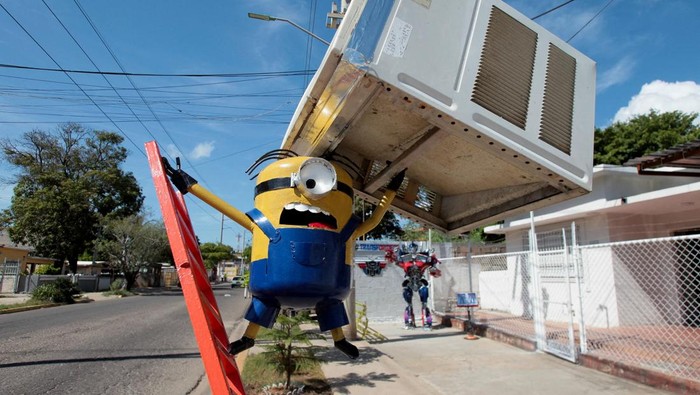 Pengrajin Venezuela Ciptakan Patung Kreatif untuk Promosikan Daur Ulang Artist Yhorby Ventura stands with a sculpture in the style of a character from Transformers that he made from recycled materials, at his house in Maracaibo, Venezuela, August 28, 2025. REUTERS/Isaac Urrutia