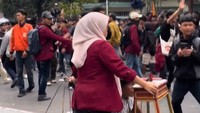 Seorang penjual kue ape terlihat terjebak di tengah aksi demonstrasi. Namun para demonstran kompak melindungi penjual tersebut dari kerumunan. Foto: TikTok