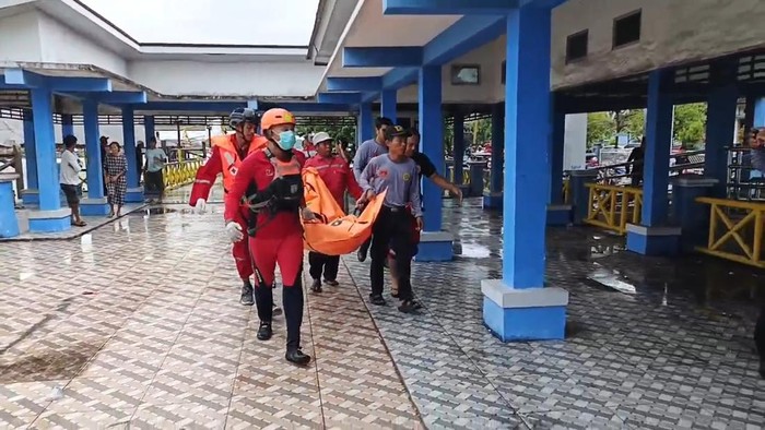 Petugas saat mengevakuasi jasad korban yang tenggelam di bawah Jembatan Ogan Palembang