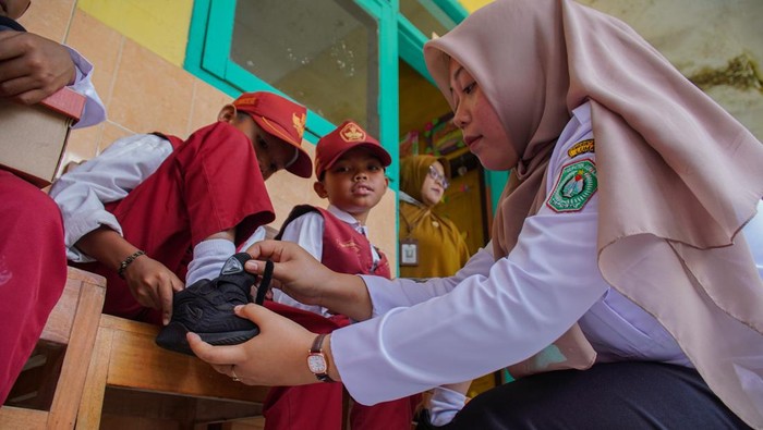 Sepatu gratis untuk siswa kurang mampu di Lumajang Siswa SD memperlihatkan sepatu gratis yang diterimanya di SD Negeri Sumbermujur 02, Kecamatan Candipuro, Lumajang, Jawa Timur, Selasa (2/9/2025). Pemkab Lumajang memberikan sepatu gratis kepada sejumlah siswa kurang mampu pada tiap kunjungan program Sehari Ngantor di Kecamatan Terpadu (Setor Madu) sebagai upaya bagian dari komitmen mewujudkan pendidikan yang inklusif dan merata bagi keluarga prasejahtera. ANTARA FOTO/Irfan Sumanjaya/foc.