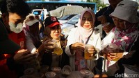 Selain warga yang mengantre, terlihat pula sejumlah relawan ikut turun tangan membantu mengatur barisan dan memungut sampah bungkus makanan yang berserakan.