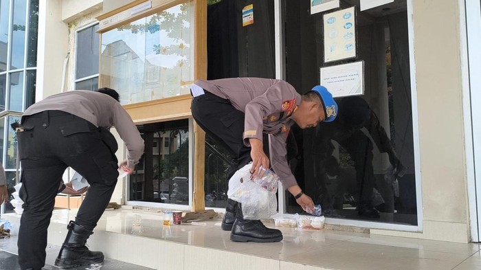 Anggota Polres Prabumulih membersihkan sampah usai demo
