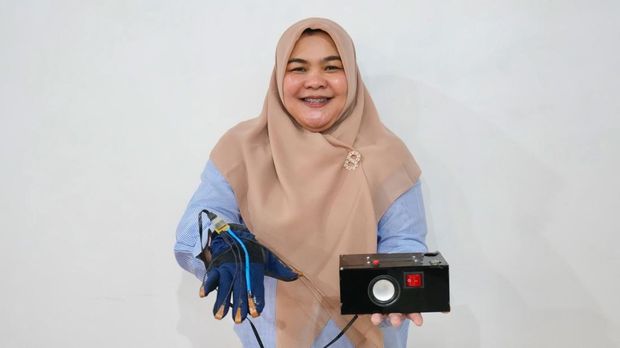 Dosen Teknik Elektro-Medis UMY, Erika Loniza saat mengenakan sarung tangan terapi relaksasi hasil ciptaannya.