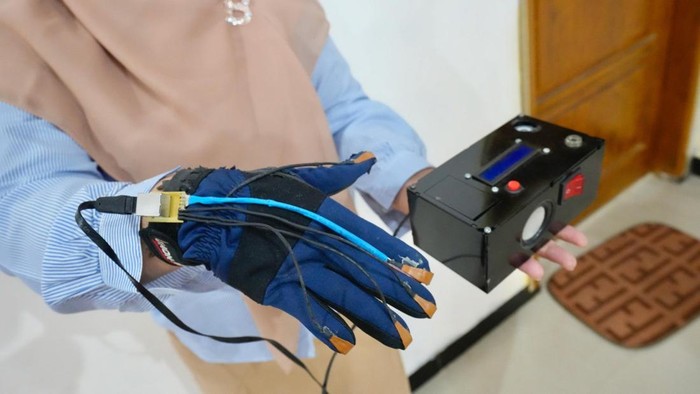 Dosen Teknik Elektro-Medis UMY, Erika Loniza saat mengenakan sarung tangan terapi relaksasi hasil ciptaannya.