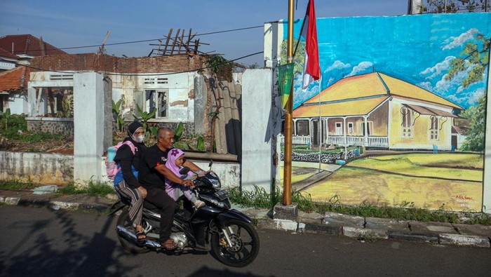 Pengendara melintas di depan mural bertemakan bangunan bersejarah di Kawasan Cagar Budaya, Depok, Jawa Barat, Rabu (3/9/2025). Pemerintah Kota Depok bersama Komunitas Mural Depok membuat mural bertemakan bangunan bersejarah yang  bertujuan untuk pelestarian aset cagar budaya serta sarana edukasi sejarah kearifan lokal untuk generasi muda. ANTARA FOTO/Yulius Satria Wijaya/foc.