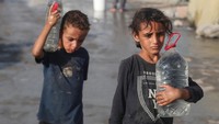 Seorang anak Palestina tampak berdiri sambil membawa wadah kosong, menanti air yang sangat dibutuhkan keluarganya. REUTERS/Mahmoud Issa