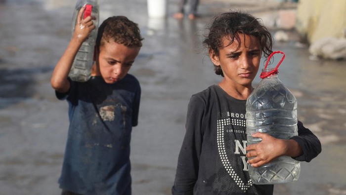 Kelangkaan Air di Gaza, Anak-Anak Palestina Ikut Antre Warga Palestina di Kota Gaza terus menghadapi krisis air bersih yang semakin parah. Rabu (3/9/2025), antrean panjang terlihat di sejumlah titik distribusi air, tak hanya orang dewasa, anak-anak pun terpaksa ikut menunggu giliran untuk mendapatkan pasokan. REUTERS/Mahmoud Issa