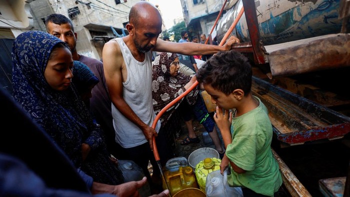 Kelangkaan Air di Gaza, Anak-Anak Palestina Ikut Antre Warga Palestina di Kota Gaza terus menghadapi krisis air bersih yang semakin parah. Rabu (3/9/2025), antrean panjang terlihat di sejumlah titik distribusi air, tak hanya orang dewasa, anak-anak pun terpaksa ikut menunggu giliran untuk mendapatkan pasokan. REUTERS/Mahmoud Issa