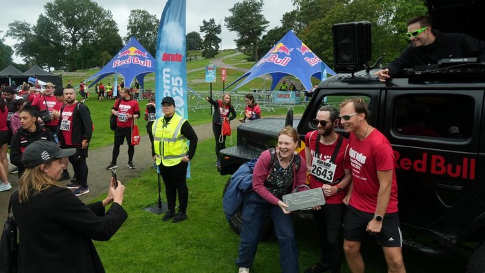 Participants of a fun run around locations in the video for the track 'Sandstorm' by Finnish electronic music artist and producer Darude reenact a scene from the video as they near the finish line in Helsinki, Finland, August 31, 2025. REUTERS/Tom Little