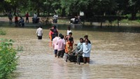 Orang-orang berjalan melalui jalan yang banjir setelah naiknya permukaan air Sungai Yamuna akibat hujan monsun lebat, di New Delhi, India, Rabu (3/9/2025). REUTERS/Anushree Fadnavis
