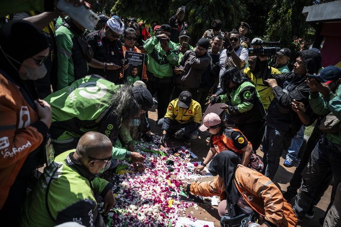 Personel Polwan menunjukkan bunga yang didapatnya dari pengemudi ojek daring dalam aksi damai di kawasan Simpang Lima, Semarang, Jawa Tengah, Rabu (3/9/2025). Aksi damai yang diikuti oleh pengemudi ojek daring se-Jawa Tengah dengan melakukan prosesi tabur bunga dan membagikan bunga kepada TNI-Polri itu digelar sebagai bentuk solidaritas sekaligus mengenang mendiang pengemudi ojek daring Affan Kurniawan yang meninggal saat unjuk rasa di Jakarta pada Kamis (28/8). ANTARA FOTO/Aprillio Akbar/foc.