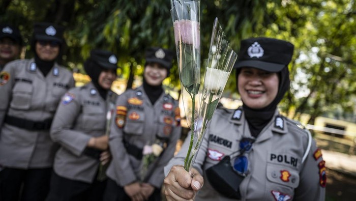 Personel Polwan menunjukkan bunga yang didapatnya dari pengemudi ojek daring dalam aksi damai di kawasan Simpang Lima, Semarang, Jawa Tengah, Rabu (3/9/2025). Aksi damai yang diikuti oleh pengemudi ojek daring se-Jawa Tengah dengan melakukan prosesi tabur bunga dan membagikan bunga kepada TNI-Polri itu digelar sebagai bentuk solidaritas sekaligus mengenang mendiang pengemudi ojek daring Affan Kurniawan yang meninggal saat unjuk rasa di Jakarta pada Kamis (28/8). ANTARA FOTO/Aprillio Akbar/foc.