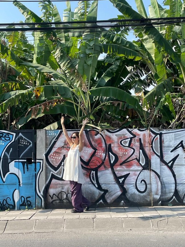 Tak disangka, pelantun lagu ‘Cosmic’ itu berpose dekat pohon pisang dan tembok berhias mural di pinggir jalan. Foto: dok. Instagram @hi_sseulgi