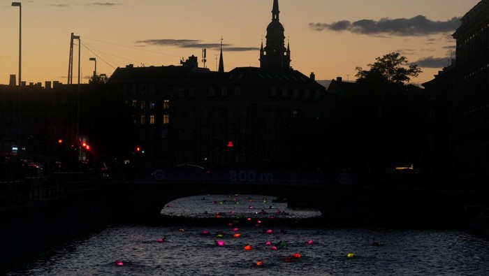 People participate in the annual night swim through the city's canals in Copenhagen, Denmark August 29, 2025. REUTERS/Tom Little