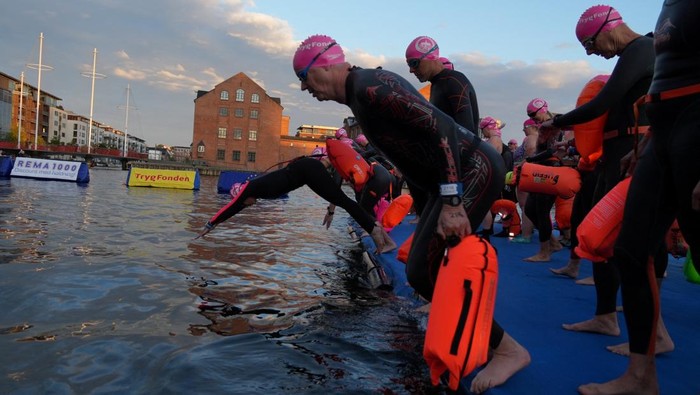 Sungai Kopenhagen Berpendar Indah Saat Renang Malam Tahunan People participate in the annual night swim through the city's canals in Copenhagen, Denmark August 29, 2025. REUTERS/Tom Little