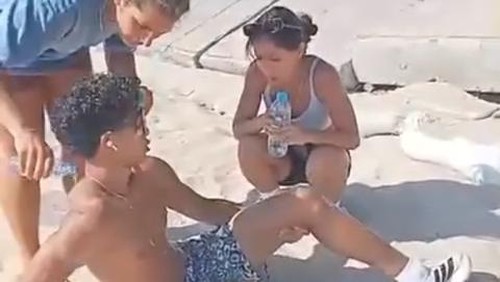 Turis asing duduk sambil menahan sakit kakinya yang diduga patah akibat jatuh di jalur pedestrian rusak di Pantau Kuta, Badung, Bali. (Tangkapan layar video viral)