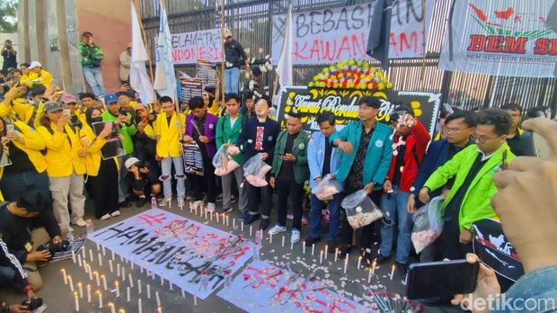 Aliansi BEM SI menggelar aksi damai di depan gedung DPR RI. Massa membagikan mawar hingga menaburkan bunga di depan pagar gedung DPR RI. (Kurniawan F/detikcom)