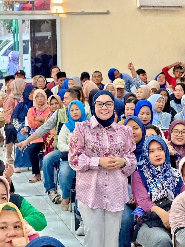 Dalam acara tatap muka bersama warga, Astrid memilih kemeja bermotif ungu pastel dengan detail floral, dipadukan celana putih dan hijab hitam. Foto: Instagram/@astridkuya