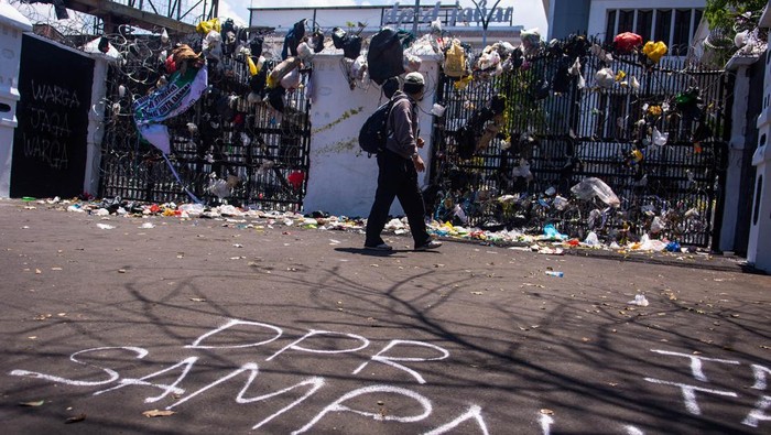 Jurnalis melihat bungkusan sampah pascaunjuk rasa Aliansi Warga Kampung Kota di depan Gedung DPRD Provinsi Jawa Barat, Bandung, Jawa Barat, Kamis (4/9/2025). Bungkusan sampah yang digantung tersebut merupakan bentuk protes atas terjadinya berbagai kekerasan ketika unjuk rasa beberapa waktu lalu sekaligus menuntut Pemerintah dan DPR agar segera membuat berbagai kebijakan yang adil kepada rakyat Indonesia. ANTARA FOTO/Novrian Arbi/nz