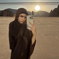 Mengambil selfie dengan latar matahari terbenam yang dramatis, Davina memadukan nuansa klasik dan modern. Hijab cokelat dikenakan sederhana namun tetap menutup sempurna. Pantulan cahaya matahari di cermin memberikan efek visual yang menawan dan kekinian. Foto: Dok. Instagram/@davinaakaramoy.