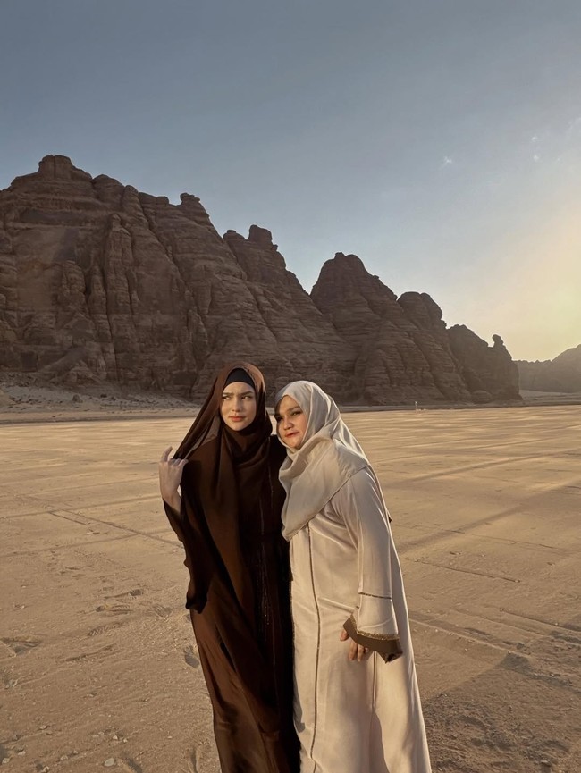 Dalam balutan outfit yang serasi namun berbeda warna, pemain film Ipar adalah Maut ini foto bersama ibunya dan terlihat kompak. Keduanya mengenakan abaya panjang dan hijab syar’i.  Foto: Dok. Instagram/@davinaakaramoy.