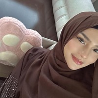 Potret close-up ini menampilkan sisi lembut Davina. Riasan natural dengan sentuhan glossy di bibir, berpadu harmonis dengan hijab cokelat polos yang dililit. Foto: Dok. Instagram/@davinaakaramoy.
