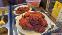 Ayam goreng Mamak berwarna merah dibumbui rempah dan digoreng krispi, menghasilkan rasa gurih berbumbu dengan tekstur daging empuk yang jadi favorit pengunjung. Foto: detikFood
