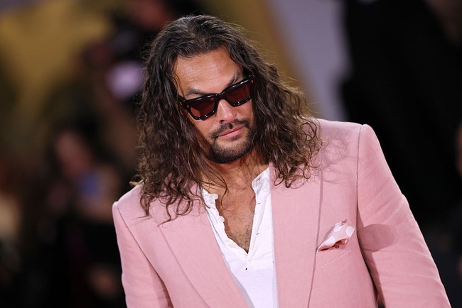 Dimulai dari atasan kaus putih V-neck yang dibungkus jas salmon pink. Sapu tangan pink bermotif polkadot ikut menghiasi sekaligus memberi kesan jenaka. (Foto: Vittorio Zunino Celotto/Getty Images)