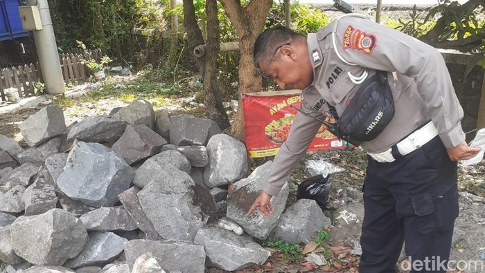 Polisi saat menunjukkan tumpukan batu TKP laka tunggal di ring road Tamantirto, Kasihan, Bantul, Kamis (4/9/2025). Pemotor tewas saat motornya oleng ketika memboncengkan temannya.