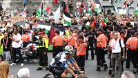 Kerumunan massa membawa bendera Palestina semakin membesar di dekat garis finis, hingga demonstran mencoba melewati pagar pembatas jalan. (Foto: Getty Images/Dario Belingheri)