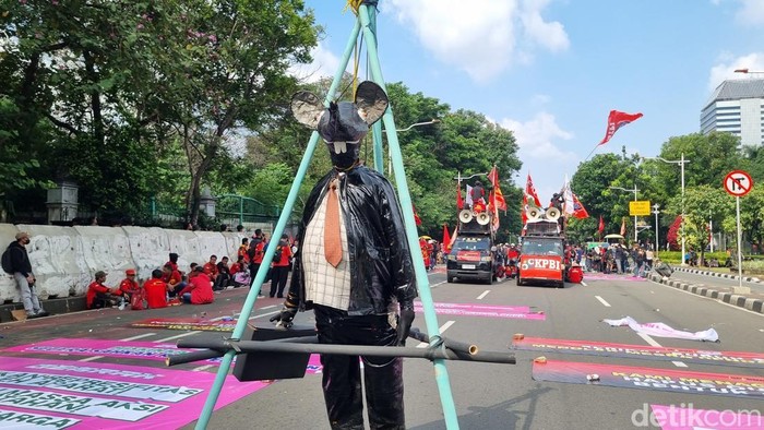 Massa buruh bawa patung berdasi saat demo di Patung Kuda, Jakpus
