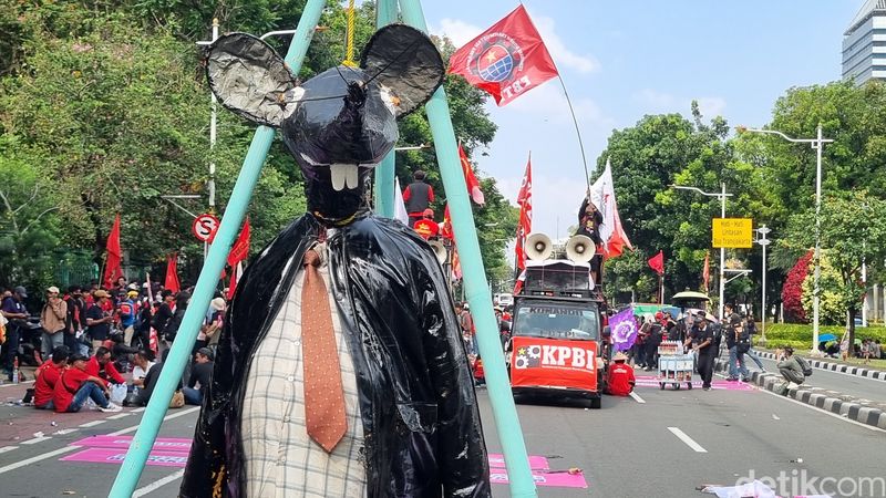 Massa buruh bawa patung berdasi saat demo di Patung Kuda, Jakpus