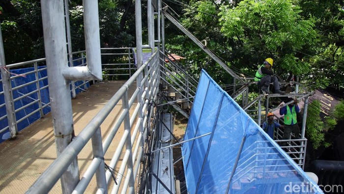 Pekerja mempersiapkan material saat perbaikan atap JPO di Jl Medan Merdeka Barat, Jakarta, Kamis (4/9/2025).