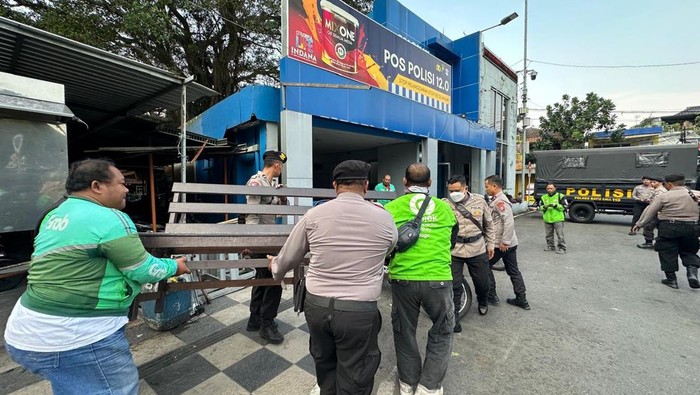 Sejumlah driver ojol bersama kepolisian kerja bakti menata pos polisi di Alun-Alun Kota Batu.