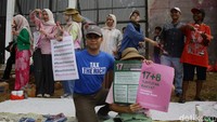 Peserta aksi membentangkan poster berisi tuntutan rakyat saat mengikuti Aksi Piknik Nasional Rakyat di depan Gedung DPR/MPR.