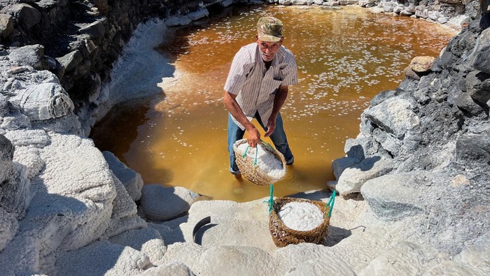 Mouhouche Oulha, 63, an Algerian salt farmer works at the village of Belayel, as they preserve a centuries-old tradition of hand-harvesting salt from a natural high-altitude lake, in Bejaia, in the Kabyle mountains of northeastern Algeria, August 30, 2025. REUTERS/Abdelaziz Boumzar     TPX IMAGES OF THE DAY