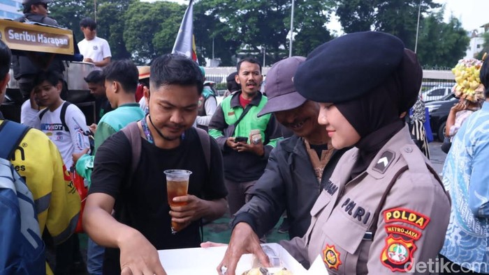 Para polwan membagikan roti, air mineral, serta memberikan pelayanan medis bagi massa aksi demo depan Gedung DPR. (dok. Polda Metro Jaya)