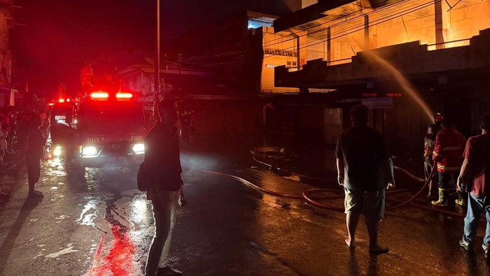 Petugas pemadam kebakaran Muara Enim tengah memadamkan api di Pasar Inpres.