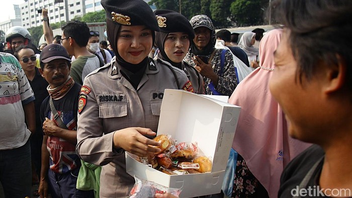 Aparat kepolisian terlihat membaur Bersama para peserta Aksi Piknik Nasional Rakyat di depan Kompleks Parlemen Senayan, Jakarta, Jumat (5/9/2025). Terlihat petugas berseragam coklat tersebut membagikan minuman dan makanan serta sebagian mengenakan peci hitam. Aksi damai yang diikuti mahasiswa dan sejumlah elemen masyarakat tersebut dilakukan untuk menagih 17+8 poin tuntutan rakyat kepada Dewan Perwakilan Rakyat.